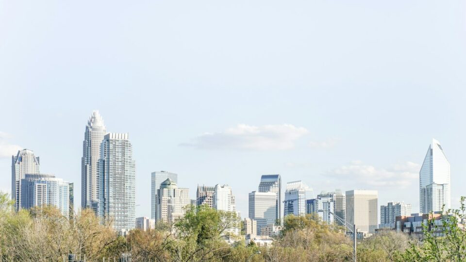 Charlotte commercial real estate skyline with office, industrial, and retail properties in a clean vector style